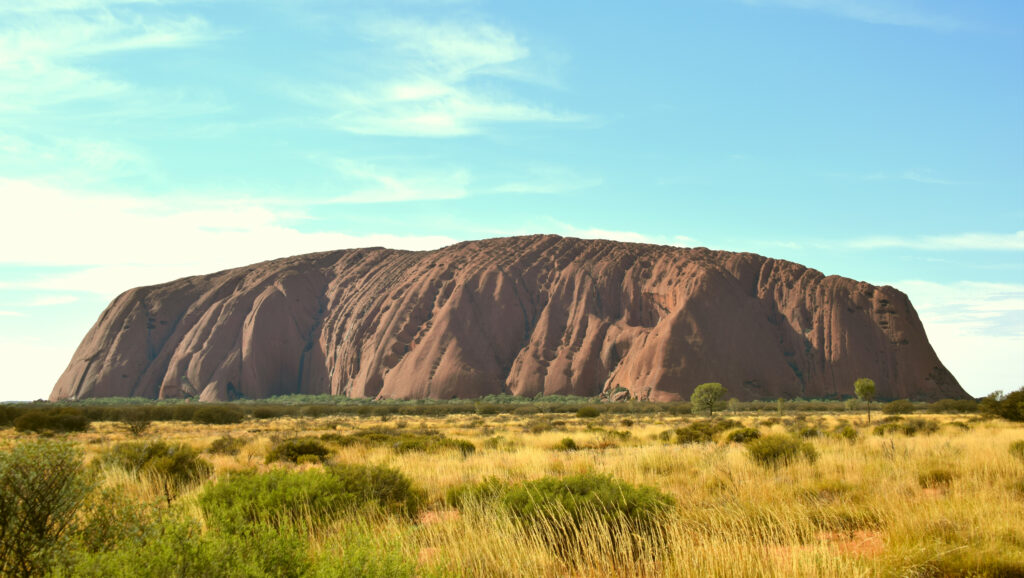 Le rocher d’Uluru se détachant sur le bush du Centre Rouge australien