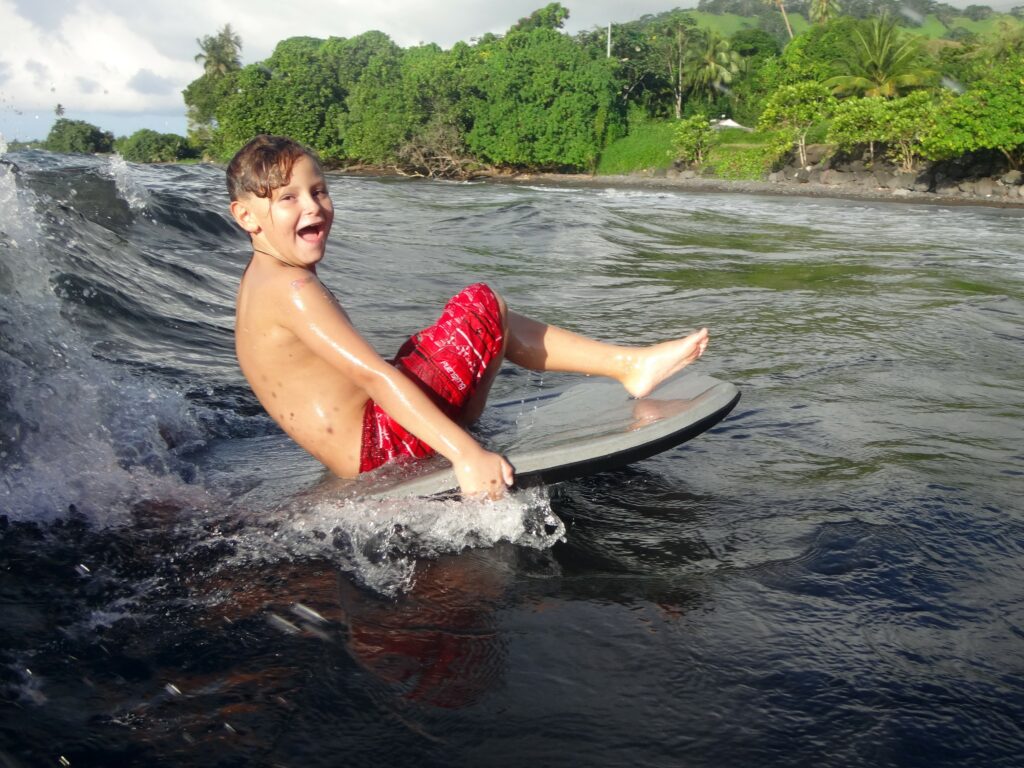 Enfant en bodyboard sur une vague à Tahiti