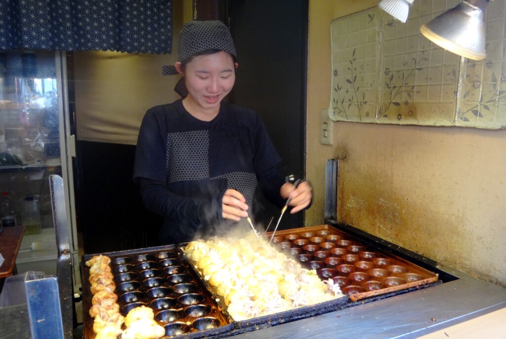 Préparation de takoyaki dans une échoppe de rue à Osaka