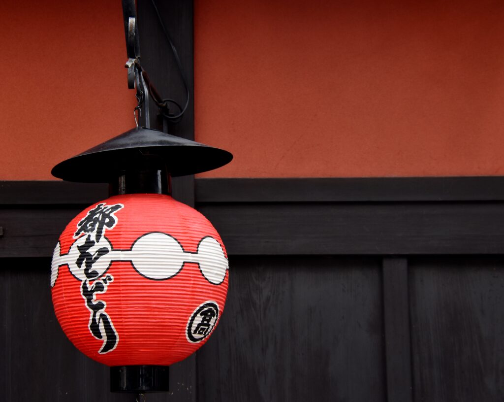 Lanterne rouge suspendue devant une façade traditionnelle japonaise